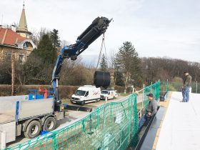 Mitarbeiter am Flachdach - übernehmen die Folie vom Kran