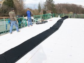 Arbeiter bei der Verlegung der Folie am Flachdach