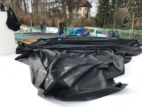 Arbeiter bei der Verlegung der Folie am Flachdach