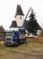 Kranarbeiten - Fällen eines Baumes neben der Kirche